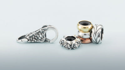 silver clasp with flowers and a small stack of spacers in silver, gold and copper